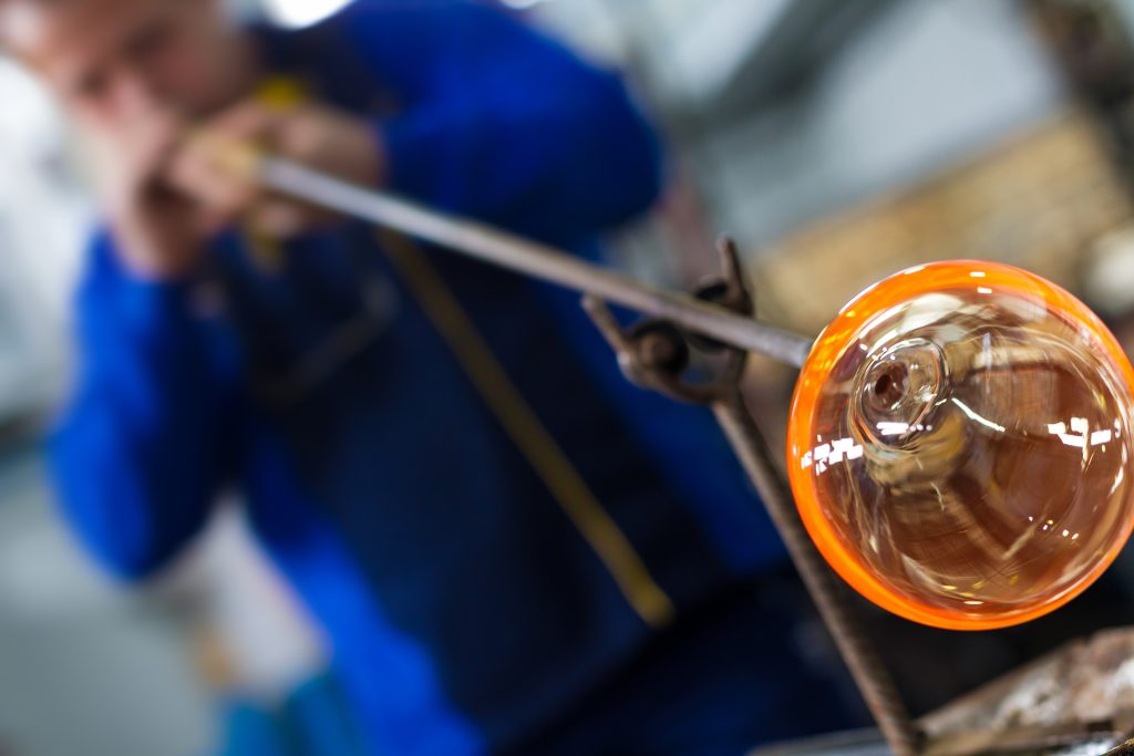 Glass blower forming beautiful piece of glass.