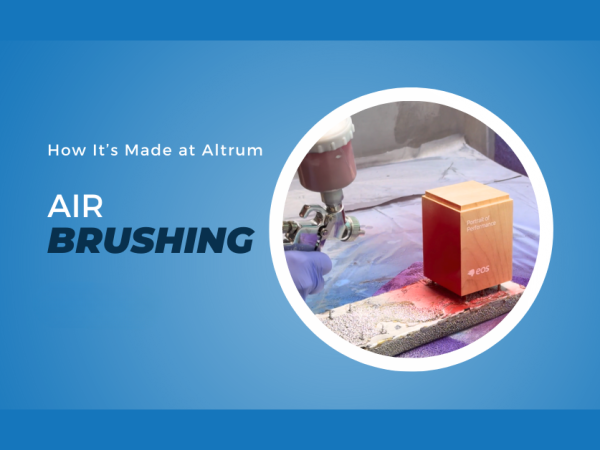 Graphic titled "How It's Made at Altrum: Air Brushing" featuring a craftsperson using a spray gun to apply a finish to a custom award, showcasing the precision airbrushing process used to achieve a high-quality finish.