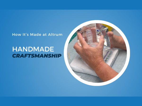 Craftsperson hand-assembling a clear acrylic award, showcasing Altrum's handmade craftsmanship and attention to detail.